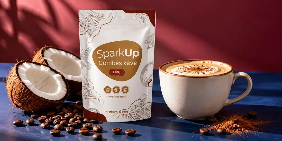 SparkUp fahéjas gombás kávé tasak, krémes kávé csészében, félbevágott kókuszdió és kávészemek kék asztalon, bordó háttér előtt